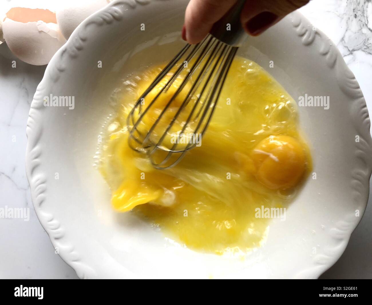Whisking eggs in a white bowl - Smartphone Captured Stock Image