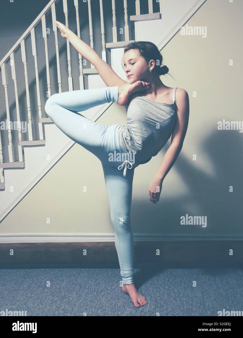 Teenage girl doing a foot to head standing yoga inspired stretch/pose Stock Photo