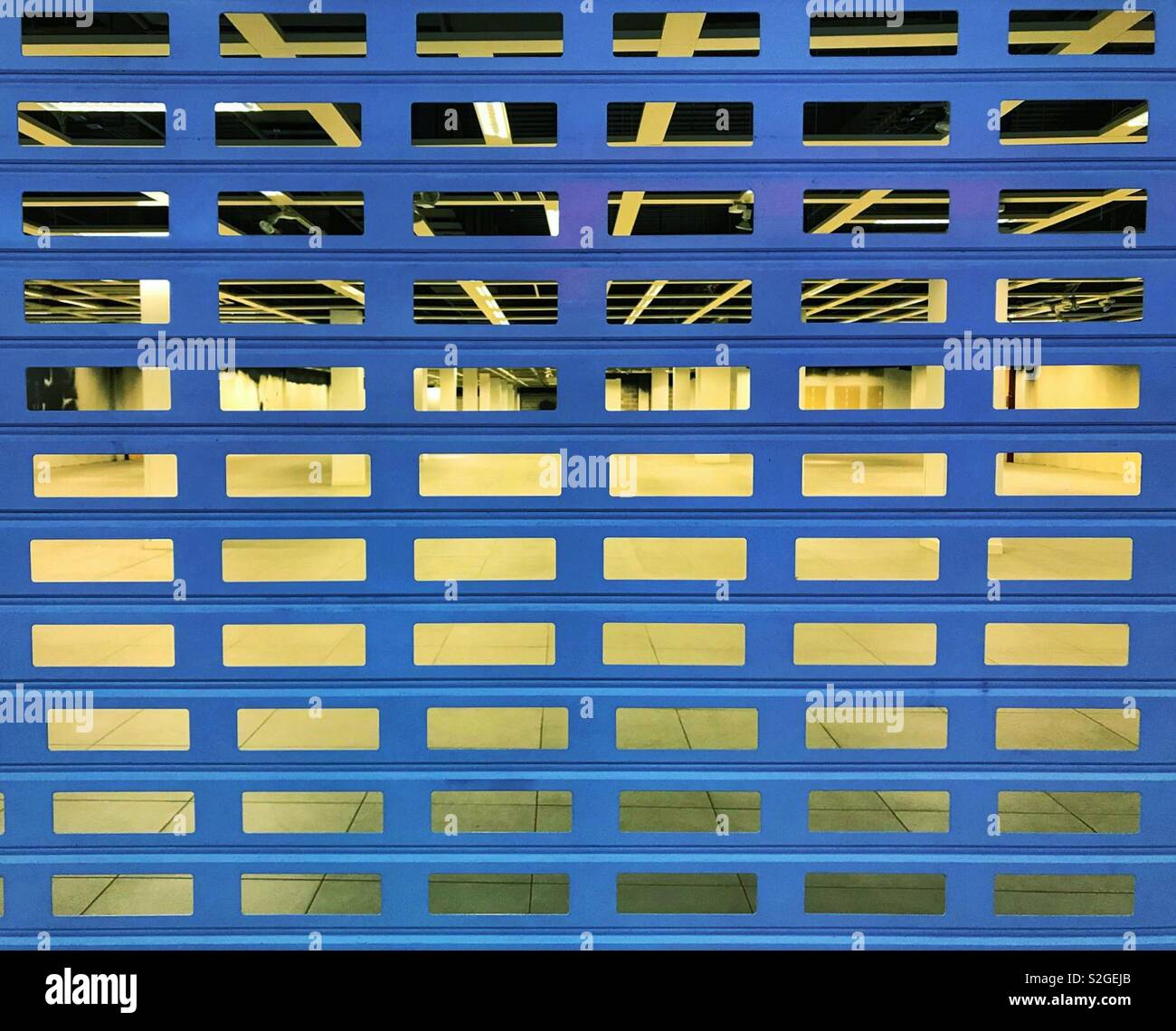 Metal security shutter over the entrance to an empty retail unit Stock Photo