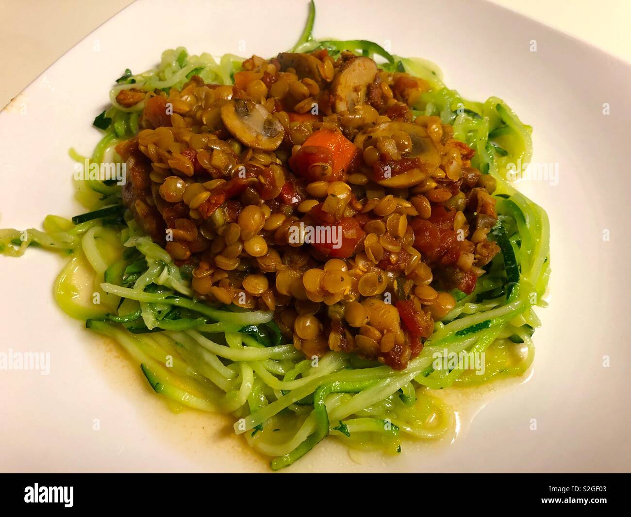 A healthy meal of vegetables and lentils in a tomato sauce over a bed of shredded zucchini ( couchette.) - Smartphone Captured Stock Image