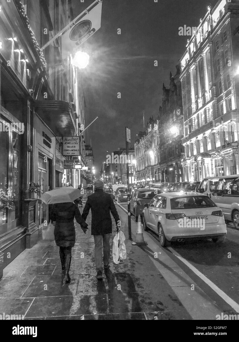 Night scene. Couple walking in St Vincent St. Glasgow city centre. Scotland. UK. - Smartphone Captured Stock Image