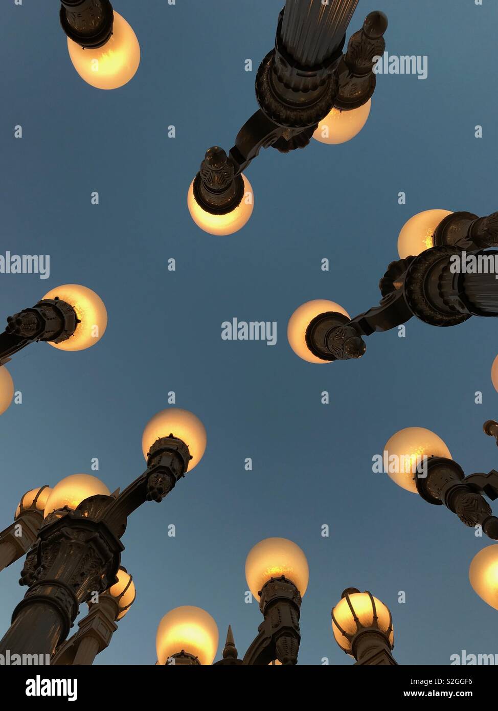 Los Angeles, CA / USA - June 29, 2018: Chris Burden’s “Urban Light” assemblage sculpture consists of 202 restored streetlights and is shown in an evening view at the Los Angeles County Museum of Art. - Smartphone Captured Stock Image