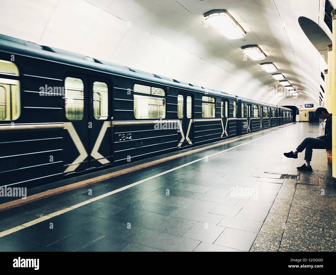 Empty Moscow subway train car arriving at the station with one passenger - Smartphone Captured Stock Image