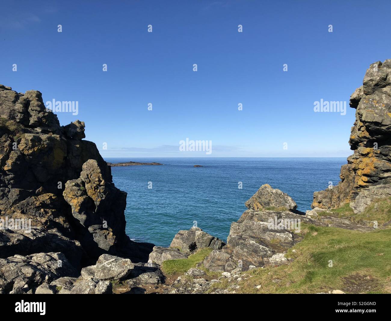Blue sea and sky through cliffs Stock Photo