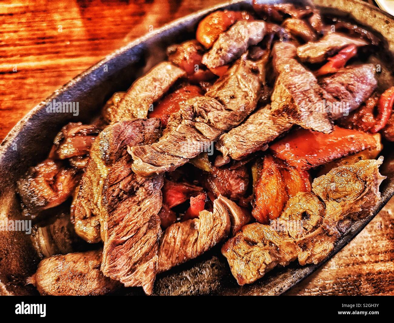 Hot sizzling dish of beef fajitas with peppers and onions Stock Photo