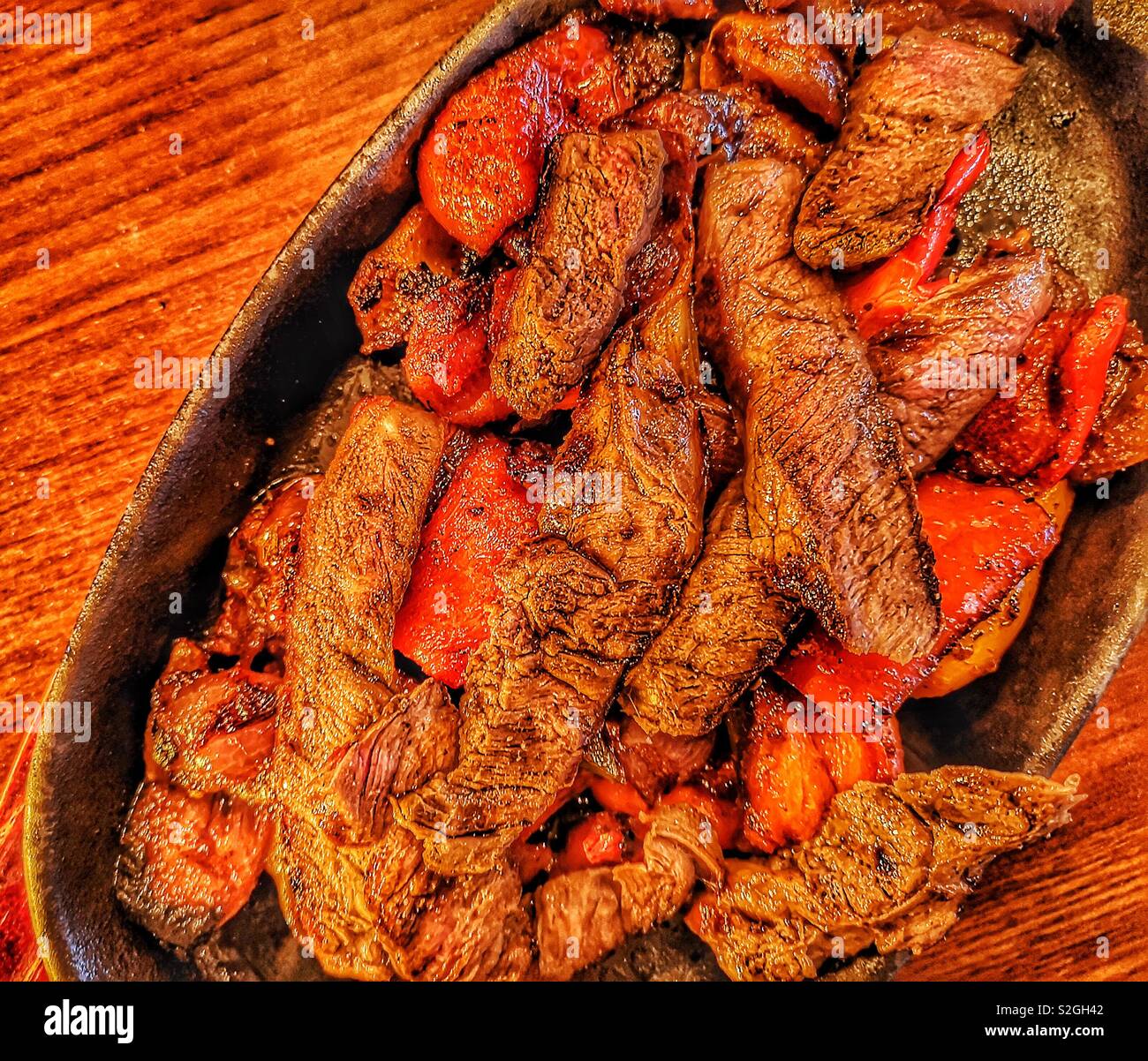 Hot sizzling dish of beef fajitas with peppers and onions - Smartphone Captured Stock Image