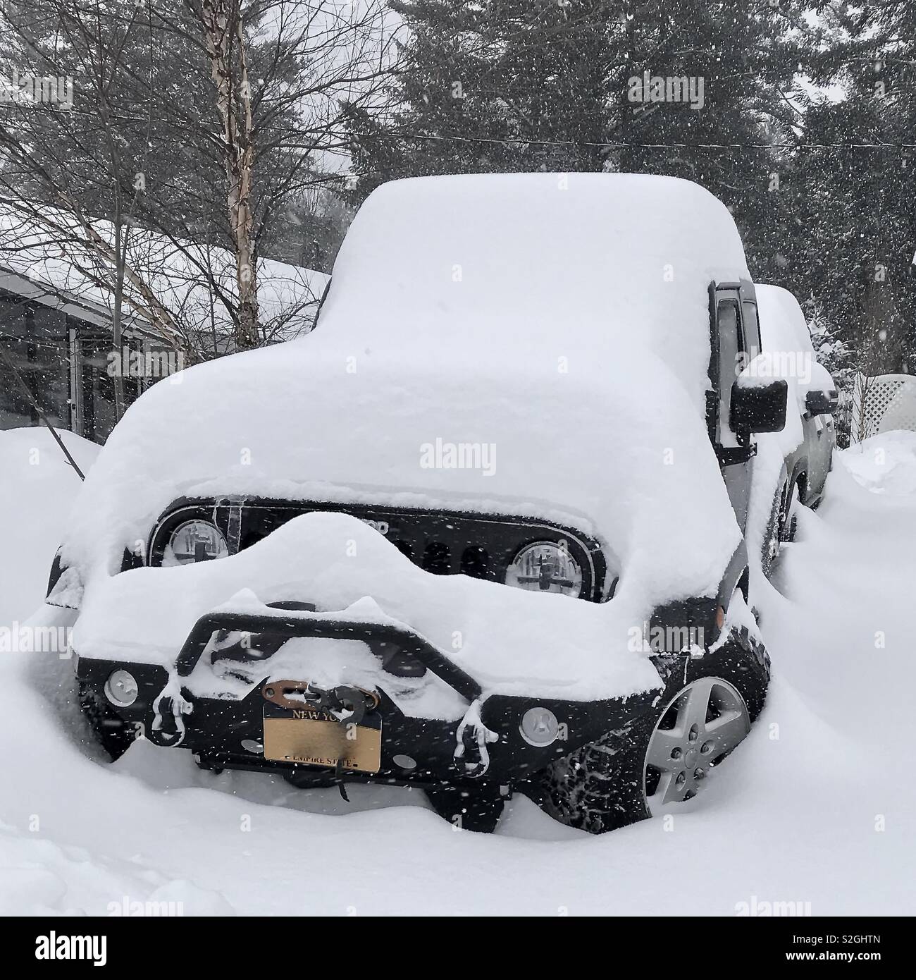 A black Jeep Wrangler covered with snow Stock Photo