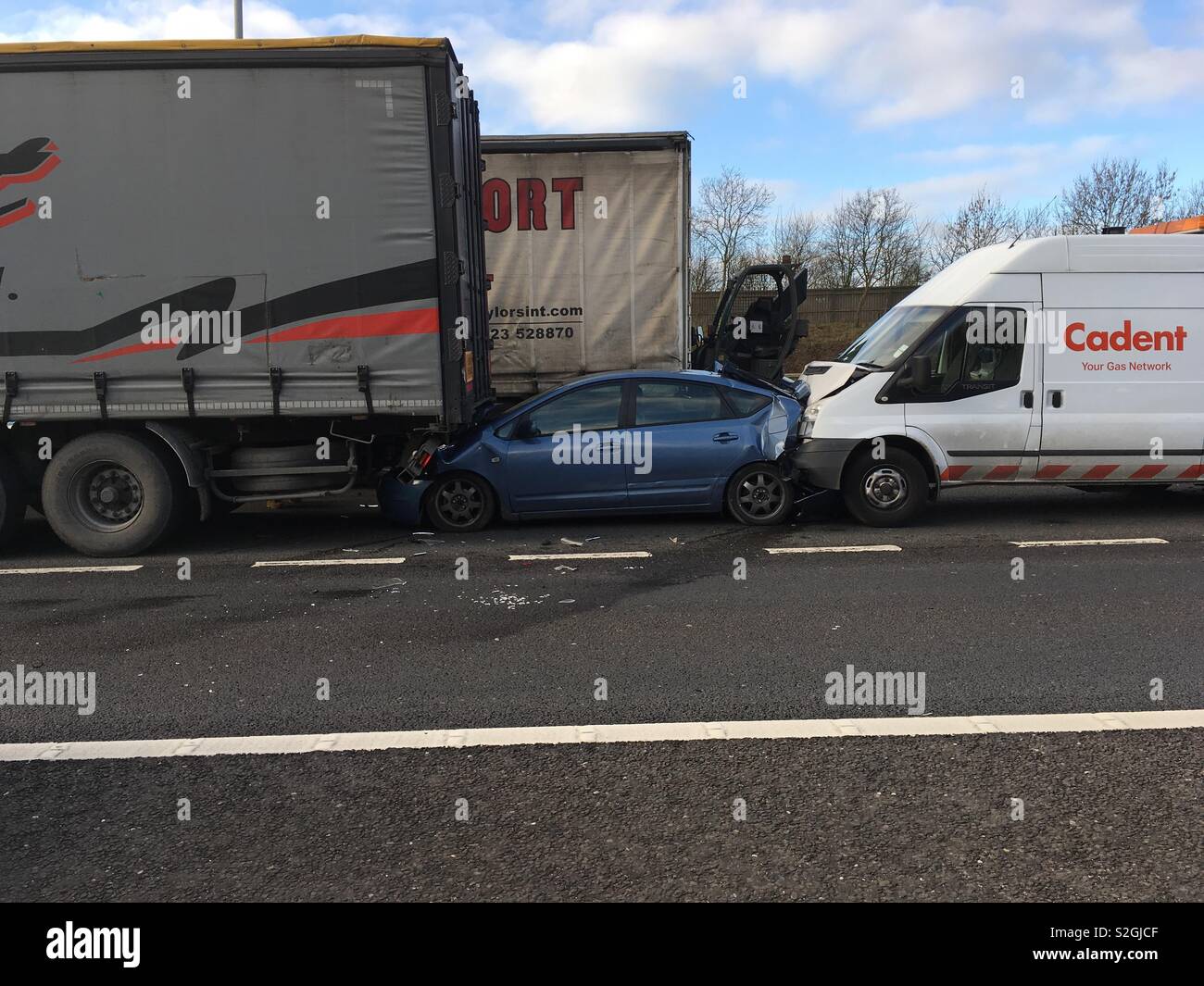 Stationary Toyota Prius squashed between 2 vehicles on M25 motorway after a truck crashed into the rear of the stationary Transit van. Stock Photo