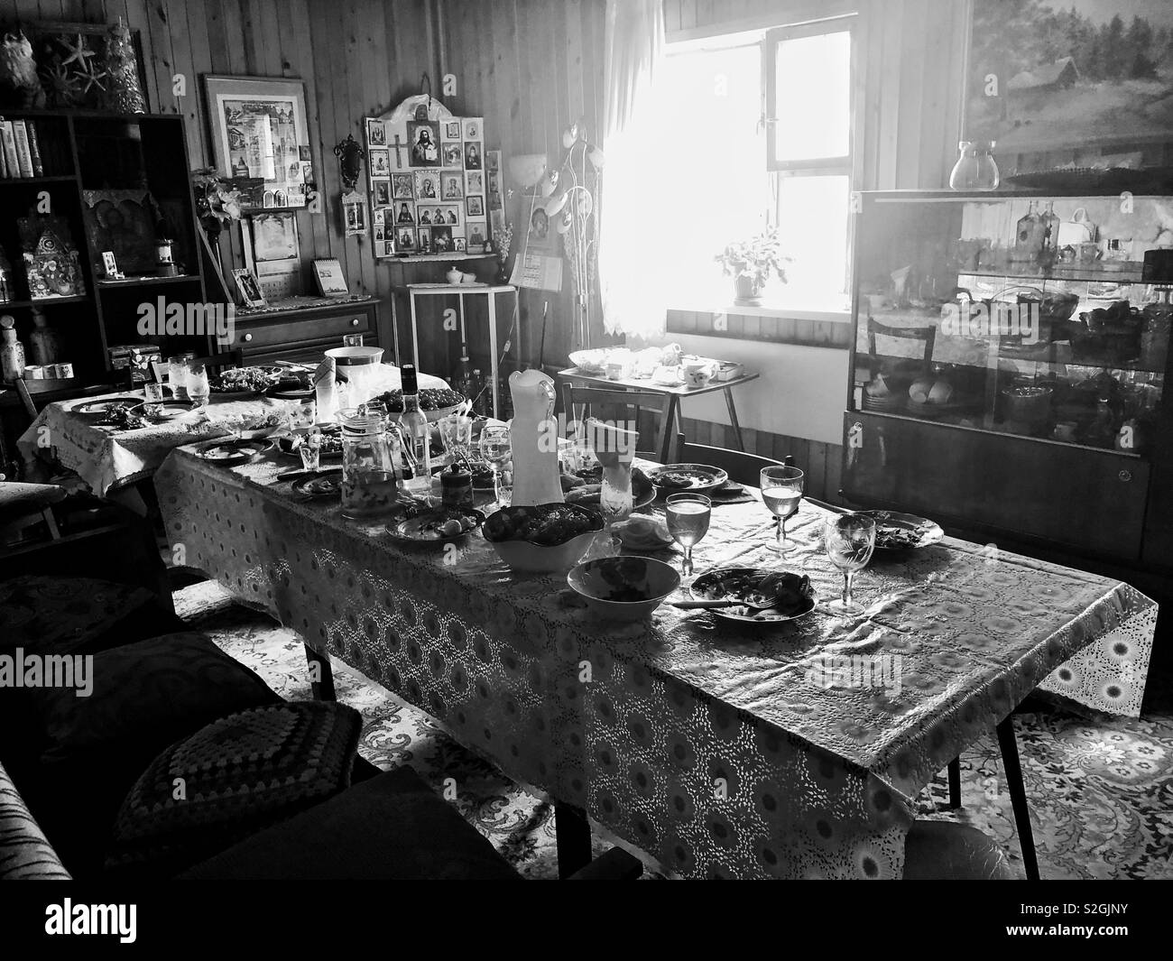 Interior of Russian dacha with icons in the corner and table set for family gathering - Smartphone Captured Stock Image