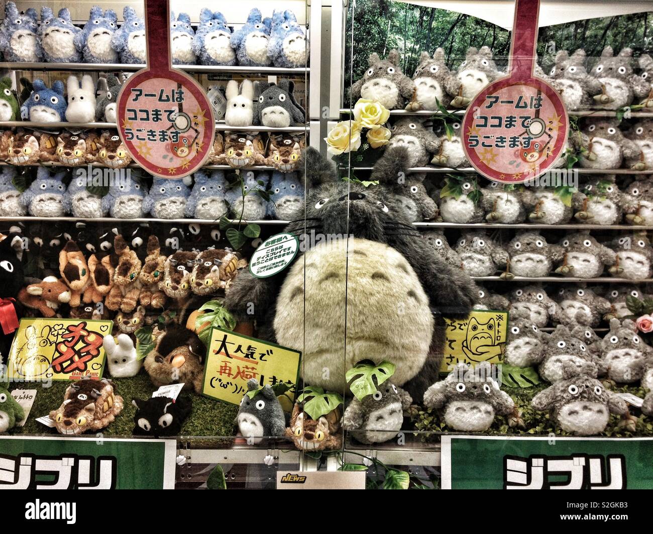 A large stuffed Totoro surrounded by smaller Totoros, cat buses and Jijis Stock Photo