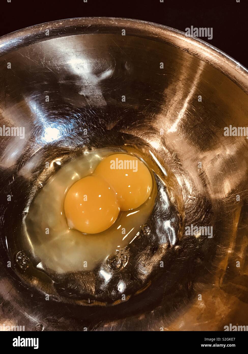Double yolk egg in a stainless steel bowl - Smartphone Captured Stock Image