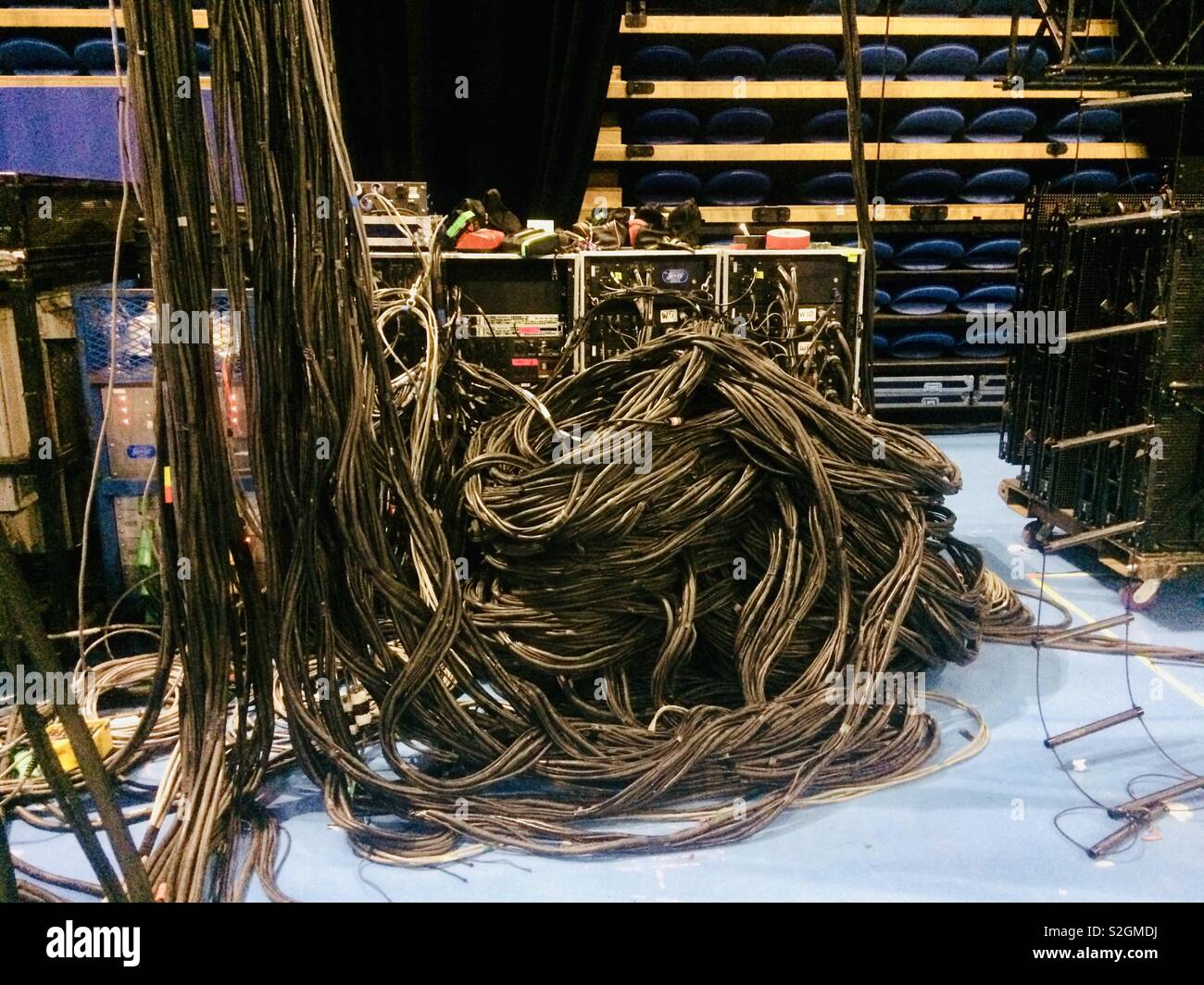 Very untidy pile of cable behind a stAge lighting power distribution rack at an arena gig / concert Stock Photo