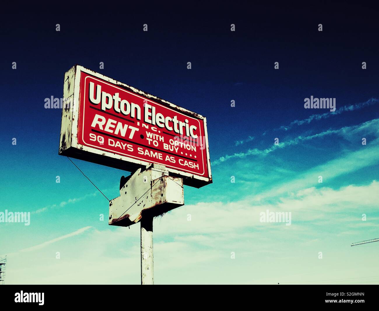 An old rusty business sign on a pole - Smartphone Captured Stock Image
