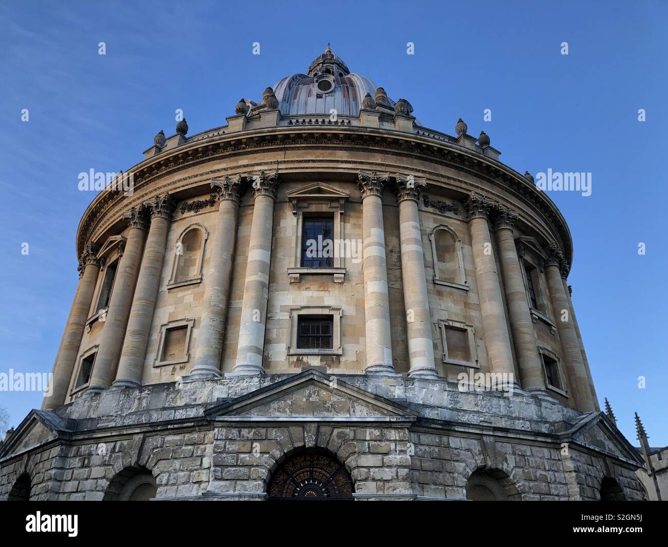 Image of famous Radcliffe Camera reading room of Bodleian Library, Oxford University at sunset with beautiful blue sky as background. Stock Photo