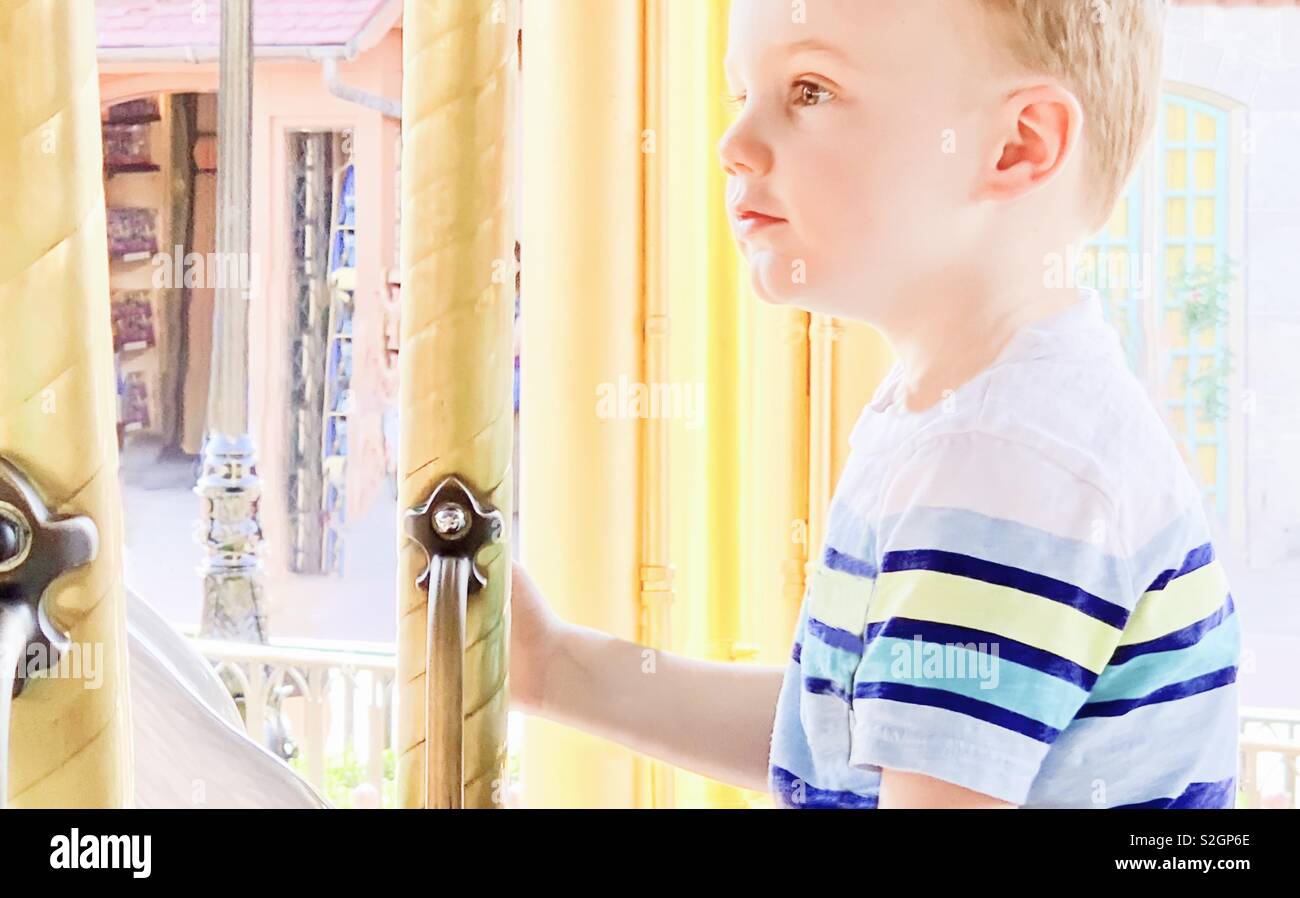 On the Carousel. A Four Year Old Enjoys the Wonder of an Old Fashioned Carousel Ride. - Smartphone Captured Stock Image