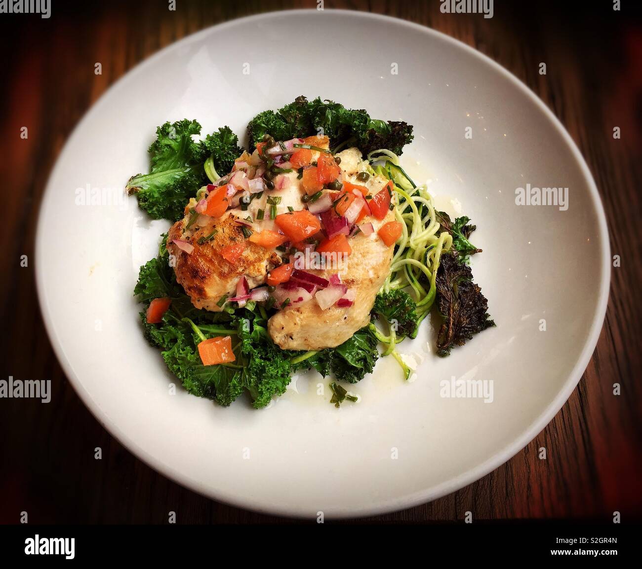 Healthy meal of grilled chicken, kale, tomato, and courgette spaghetti - Smartphone Captured Stock Image