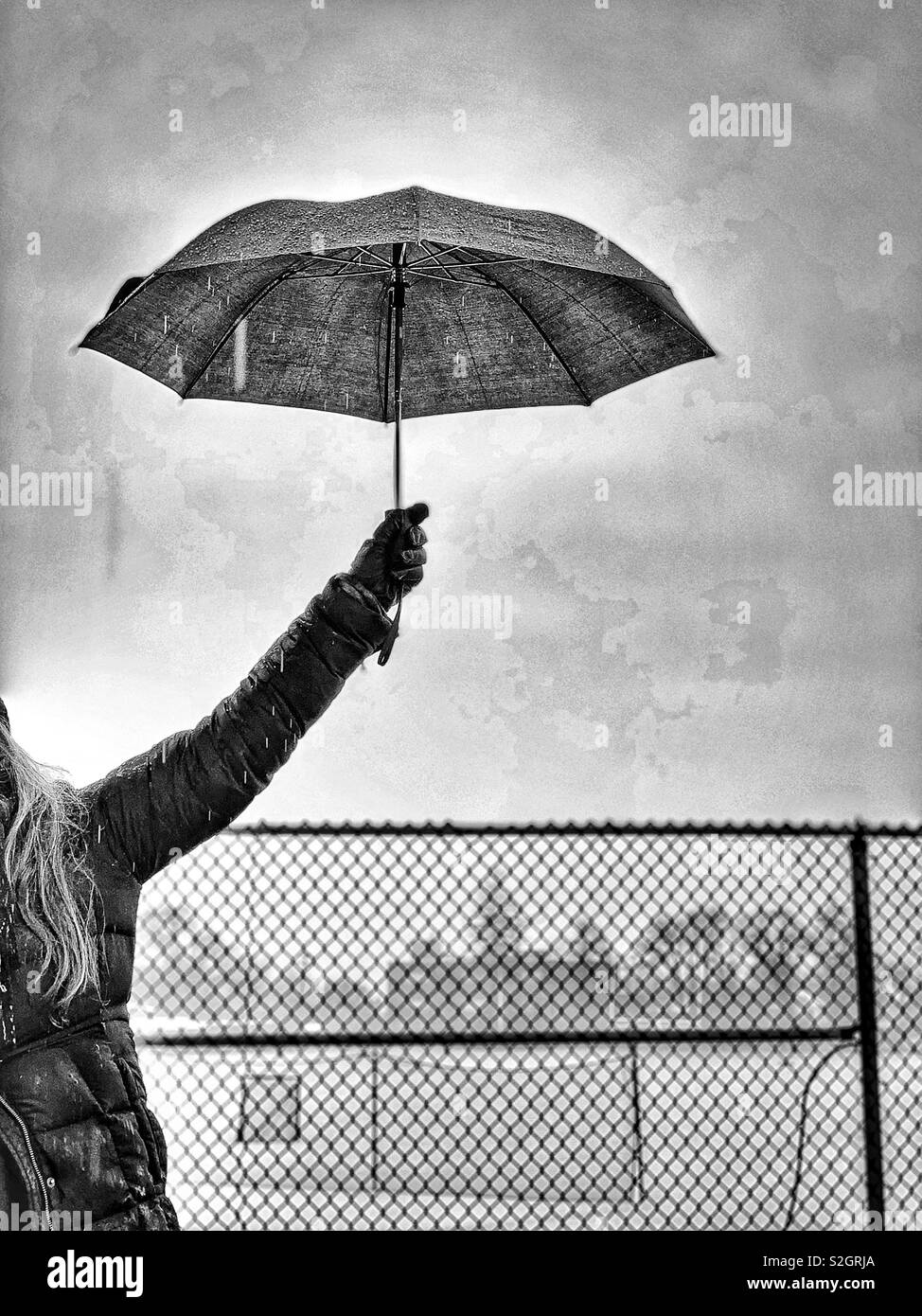 Woman holding up umbrella Stock Photo