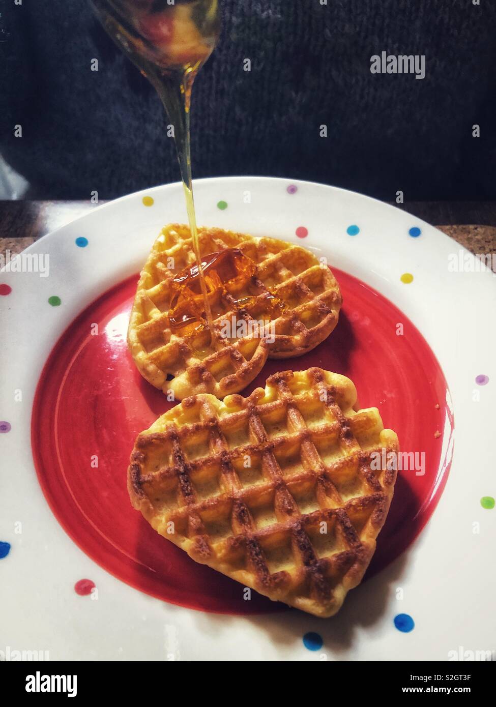 Valentine’s Day breakfast treat, heart shaped waffles with syrup Stock Photo