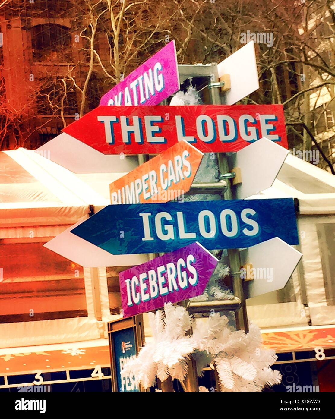 Decorative sign post points to the different events in the bank of America Winter Village frost fest, Bryant Park, NYC, USA Stock Photo