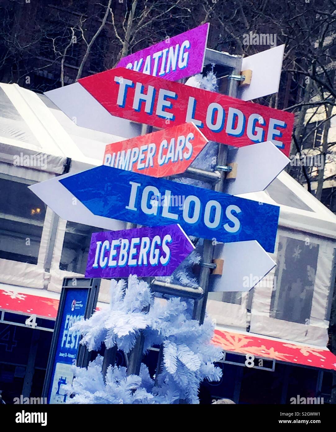 Decorative sign post points to the different events in the bank of America Winter Village frost fest, Bryant Park, NYC, USA - Smartphone Captured Stock Image
