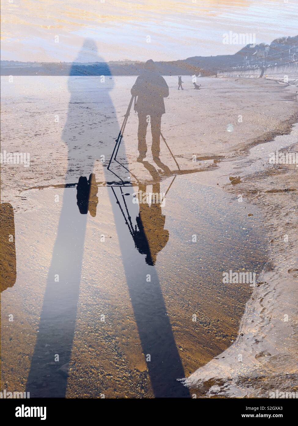 Double exposure of shadows and reflections of photographers on a beach - Smartphone Captured Stock Image
