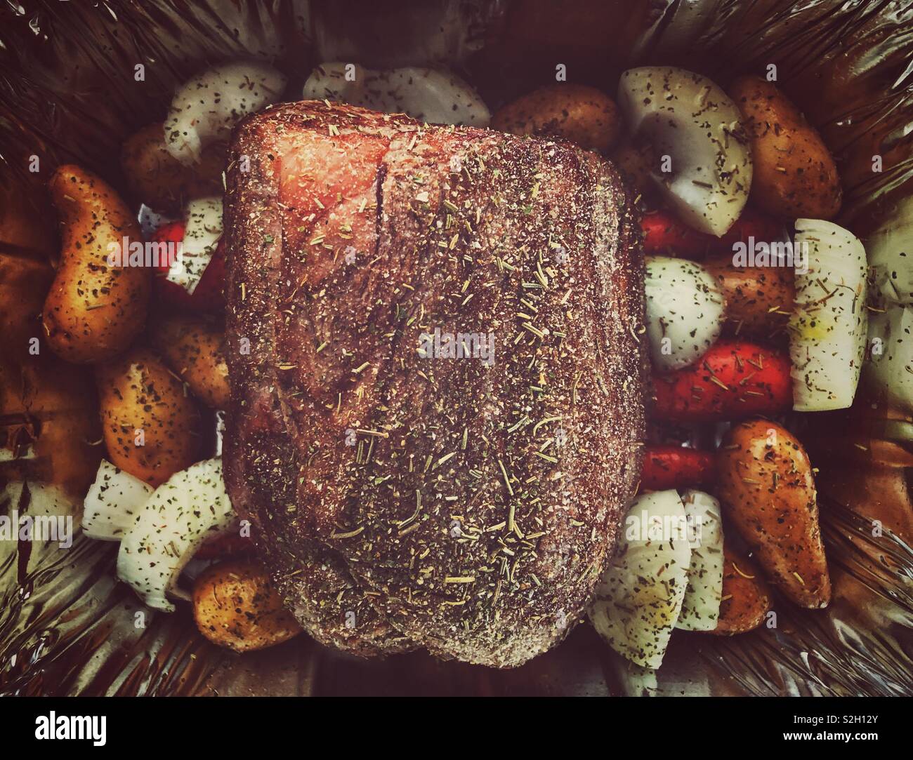 Raw, seared and seasoned roast beef with vegetables about to go in oven Stock Photo