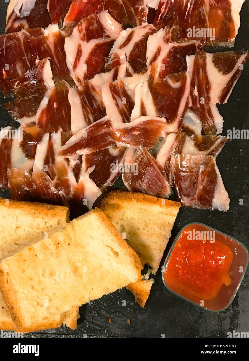 Iberian ham with toasts and tomado sauce. View from above. - Smartphone Captured Stock Image
