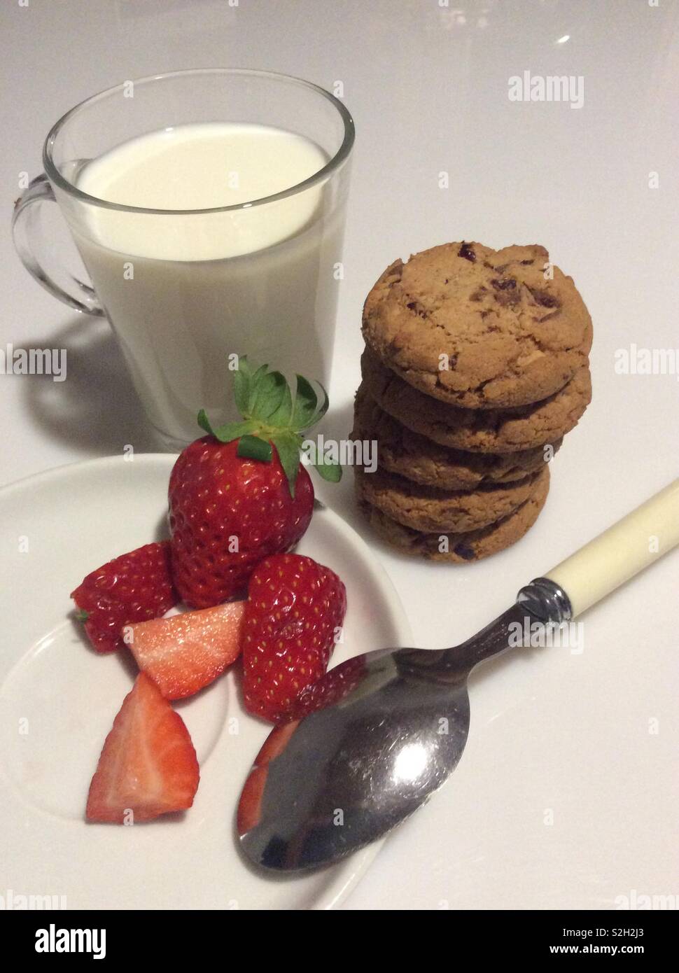 Breakfast with milk, stack of homemade cranberry and chocolate cookies and fresh strawberries Stock Photo