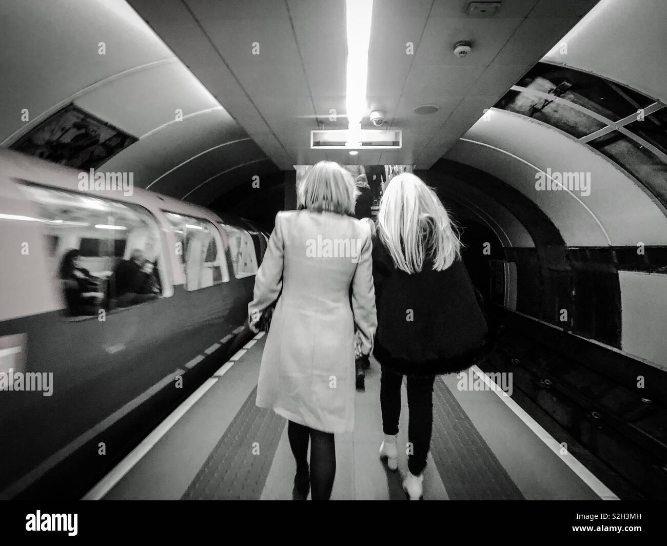 Subway train leaving station and passengers leaving platform. Glasgow, Scotland, UK. - Smartphone Captured Stock Image