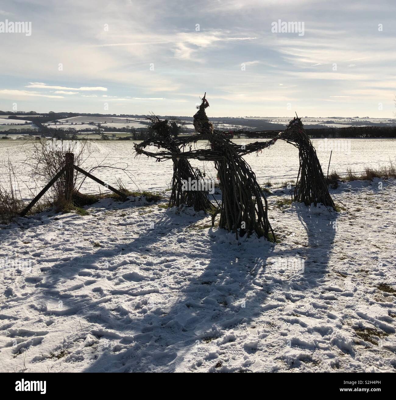 Atmospheric Three Witches woven sculpture at the Rollright Stone Circle set in brightly lit but bleak Cotswold winter landscape. Stock Photo