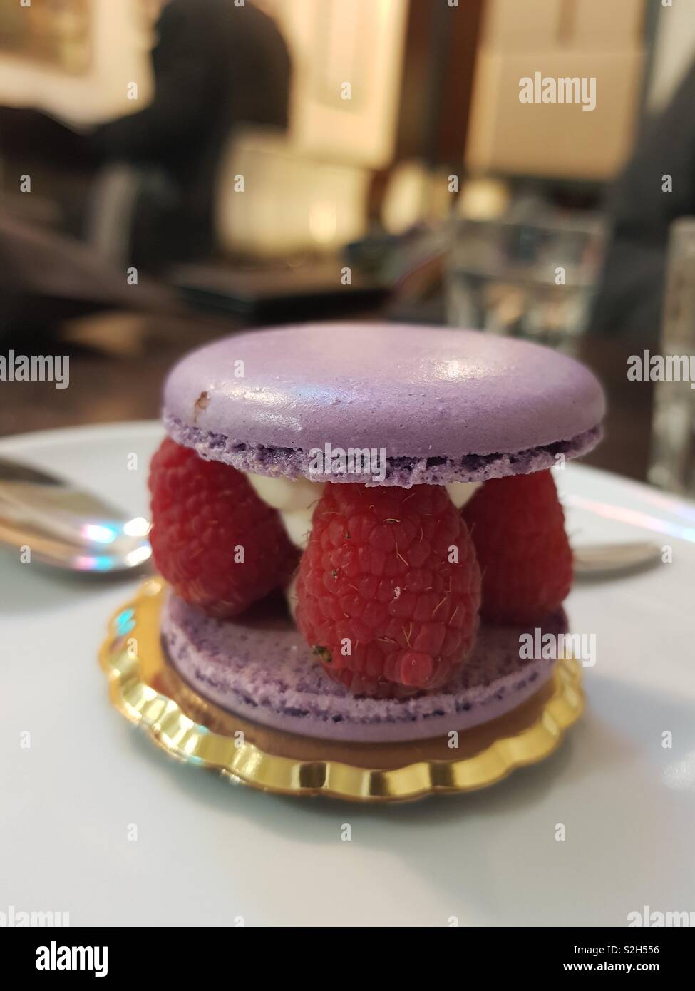 Sandwich macaron filled with chantilly cream and raspberries at the bar - Smartphone Captured Stock Image