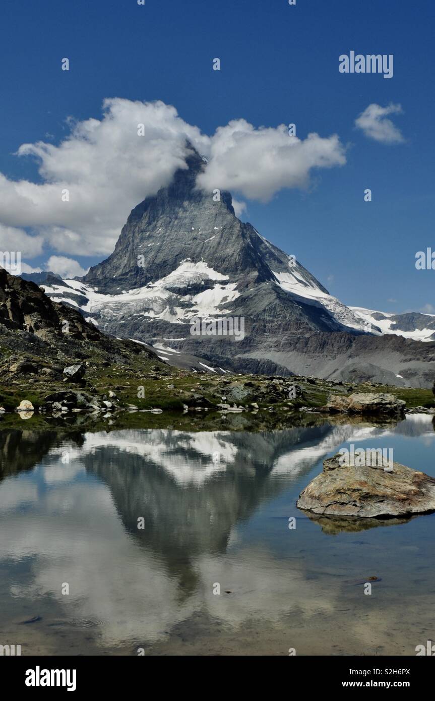 The Matterhorn reflecting in the lake in the summer sun in Switzerland. Stock Photo