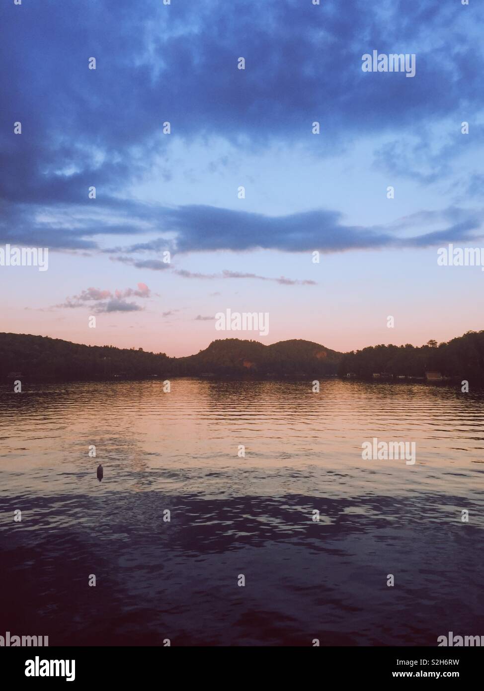 Buoy in the water at sunset on lake of bays in northern Ontario. Muskoka cottage country. - Smartphone Captured Stock Image