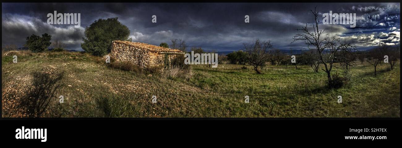 A remote abandoned farm building overlooked by a dramatic sky, Ribera d’Ebre, Catalonia, Spain. - Smartphone Captured Stock Image