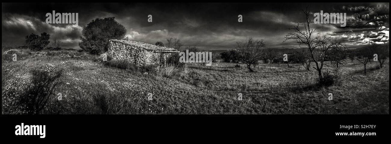 A remote abandoned farm building overlooked by a dramatic sky, Ribera d’Ebre, Catalonia, Spain. - Smartphone Captured Stock Image