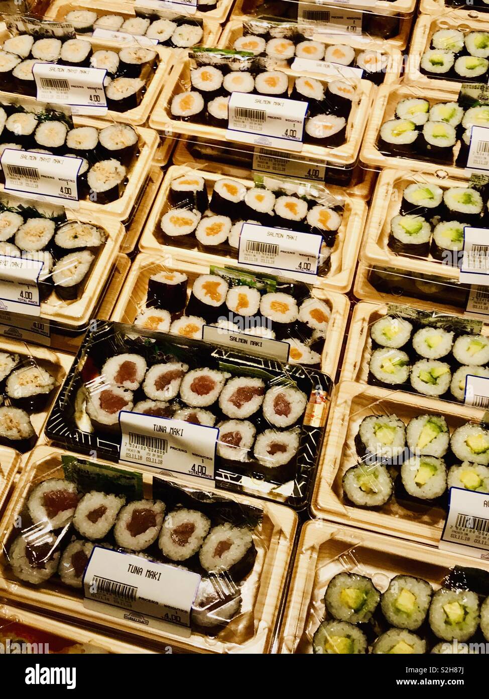 Sushi food display, raw seafood, tuna, avocado, rice and salmon in a supermarket Stock Photo
