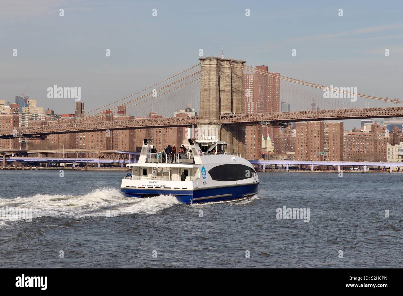Tourist boat travelling down Hudson River towards the Brooklyn Bridge Stock Photo