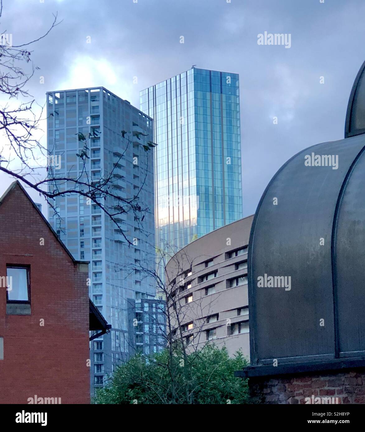 View of the Manchester City centre sky line at sunset, with a variety of buildings, old and new, with interesting contrasting geometric forms and including part of Chethams School of Music. - Smartphone Captured Stock Image