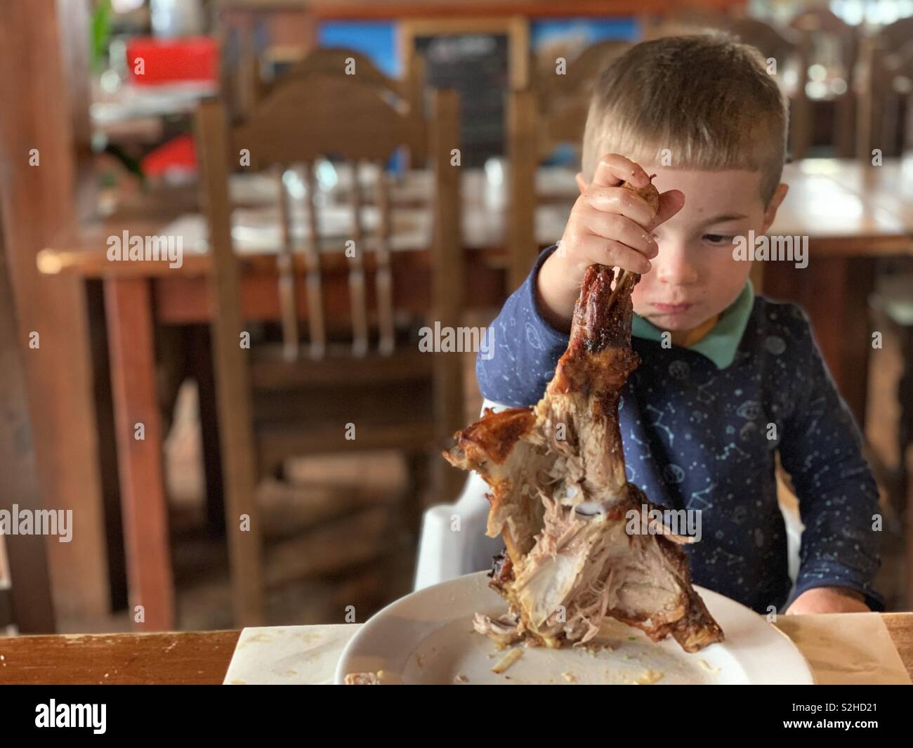 Little boy eating meat Stock Photo Alamy