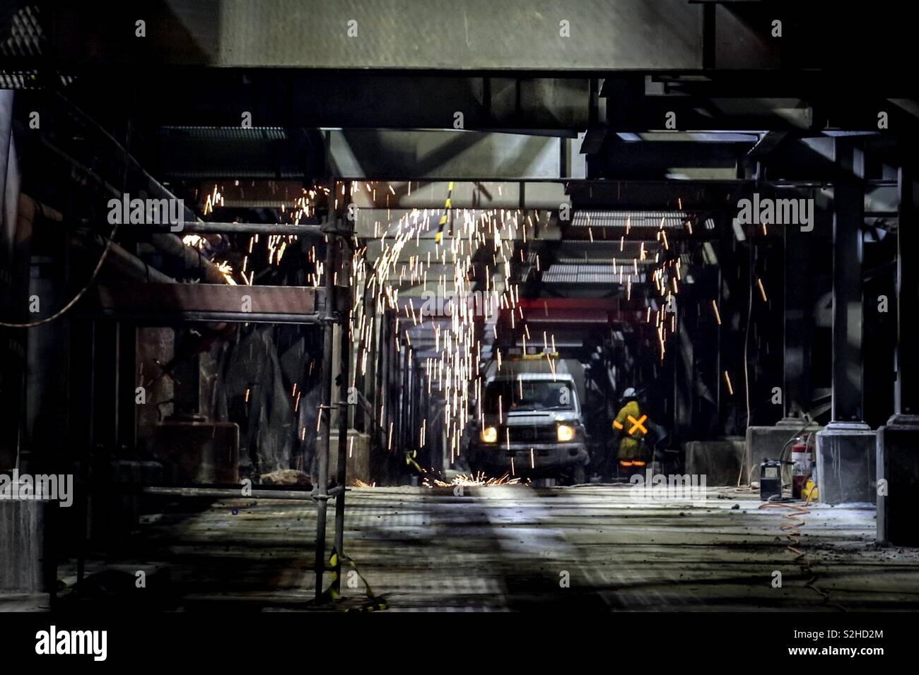 Welding underground. Sparks cascading down from a welder underground - Smartphone Captured Stock Image