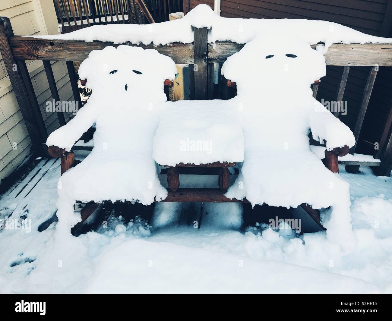 Anthropomorphic snow covered bench Stock Photo