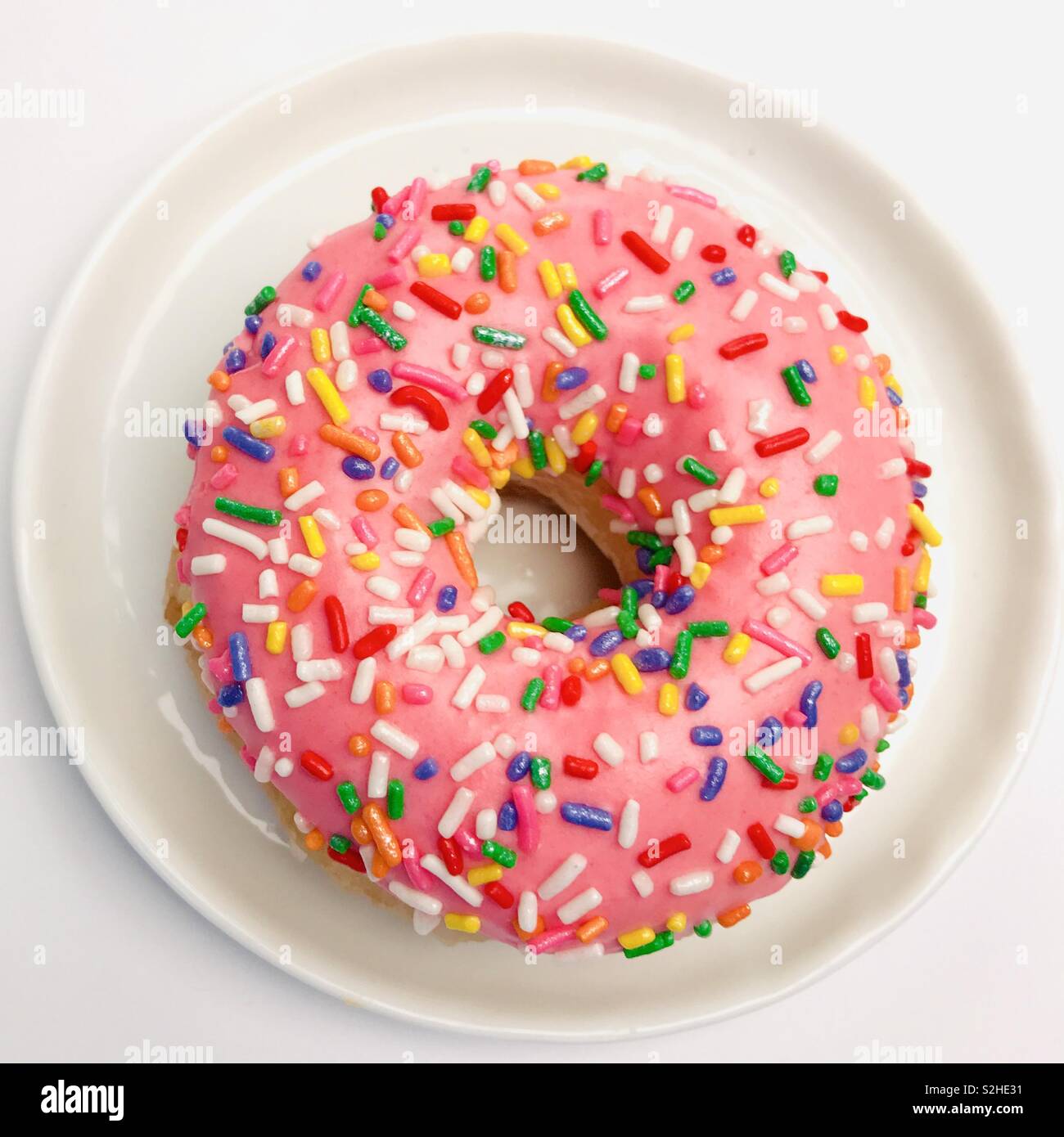 Top down view of a pink sprinkle donut. Stock Photo