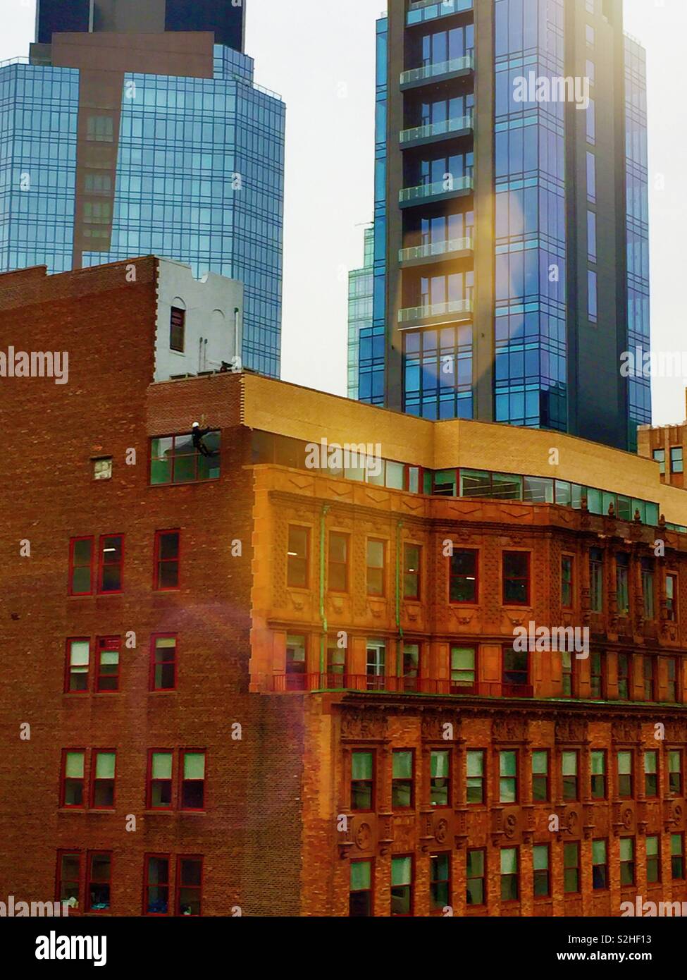 Industrial engineer rappelling down the side of  the Madison-Belmont building on a structural inspection, NYC, USA - Smartphone Captured Stock Image