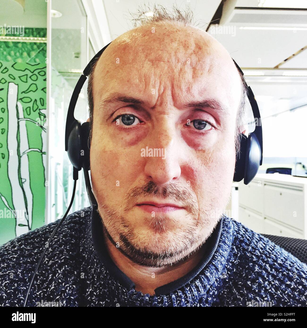 Middle aged man wearing a computer headset. - Smartphone Captured Stock Image