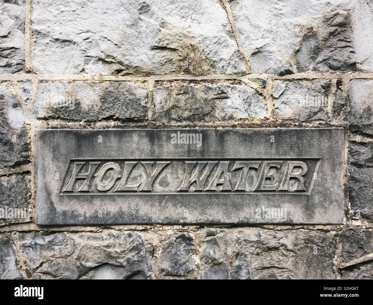 Holy water etched in rock at Ennis friary in Ireland. - Smartphone Captured Stock Image
