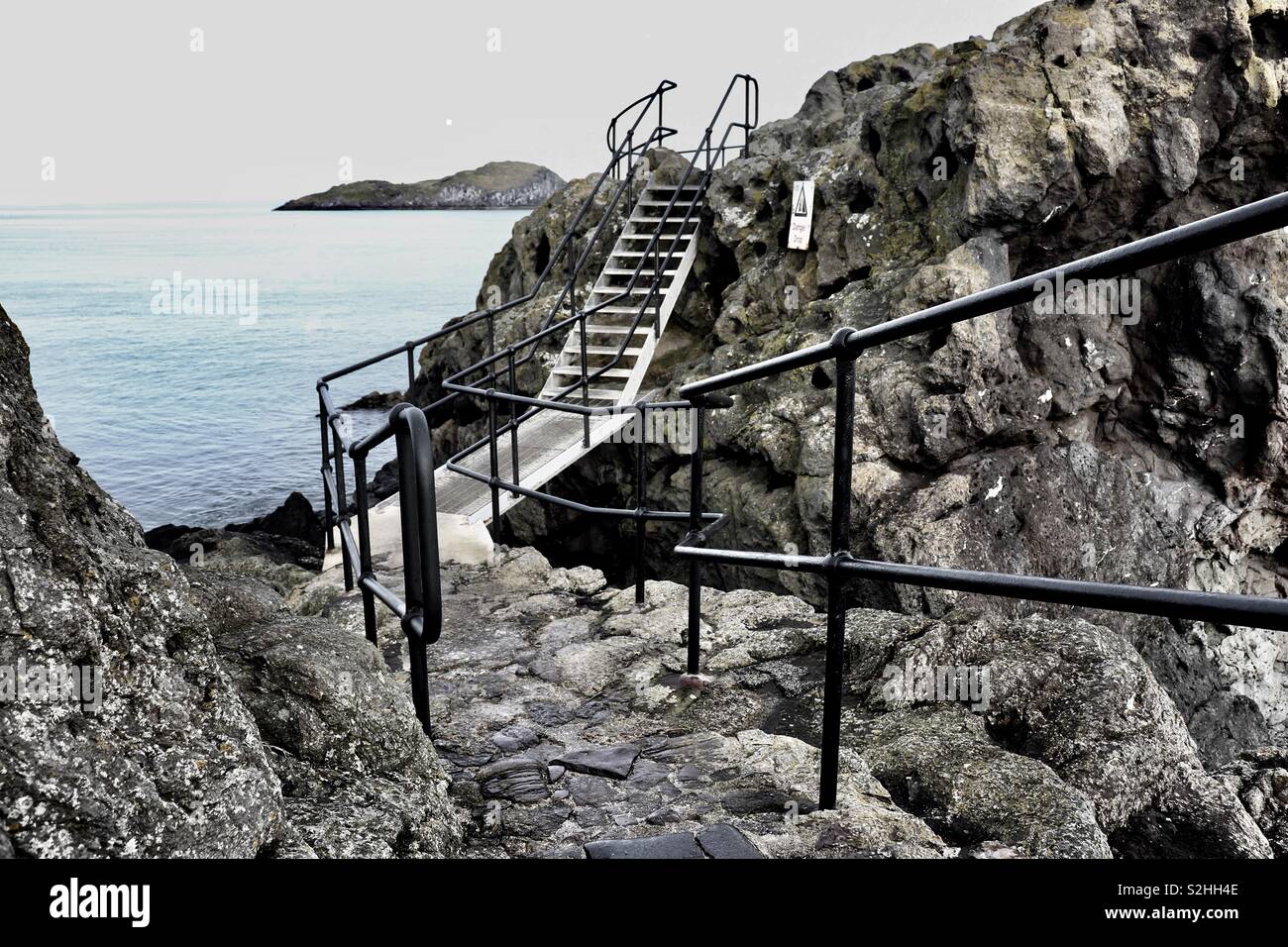 Outdoor metal walkway across coastal rocks Stock Photo