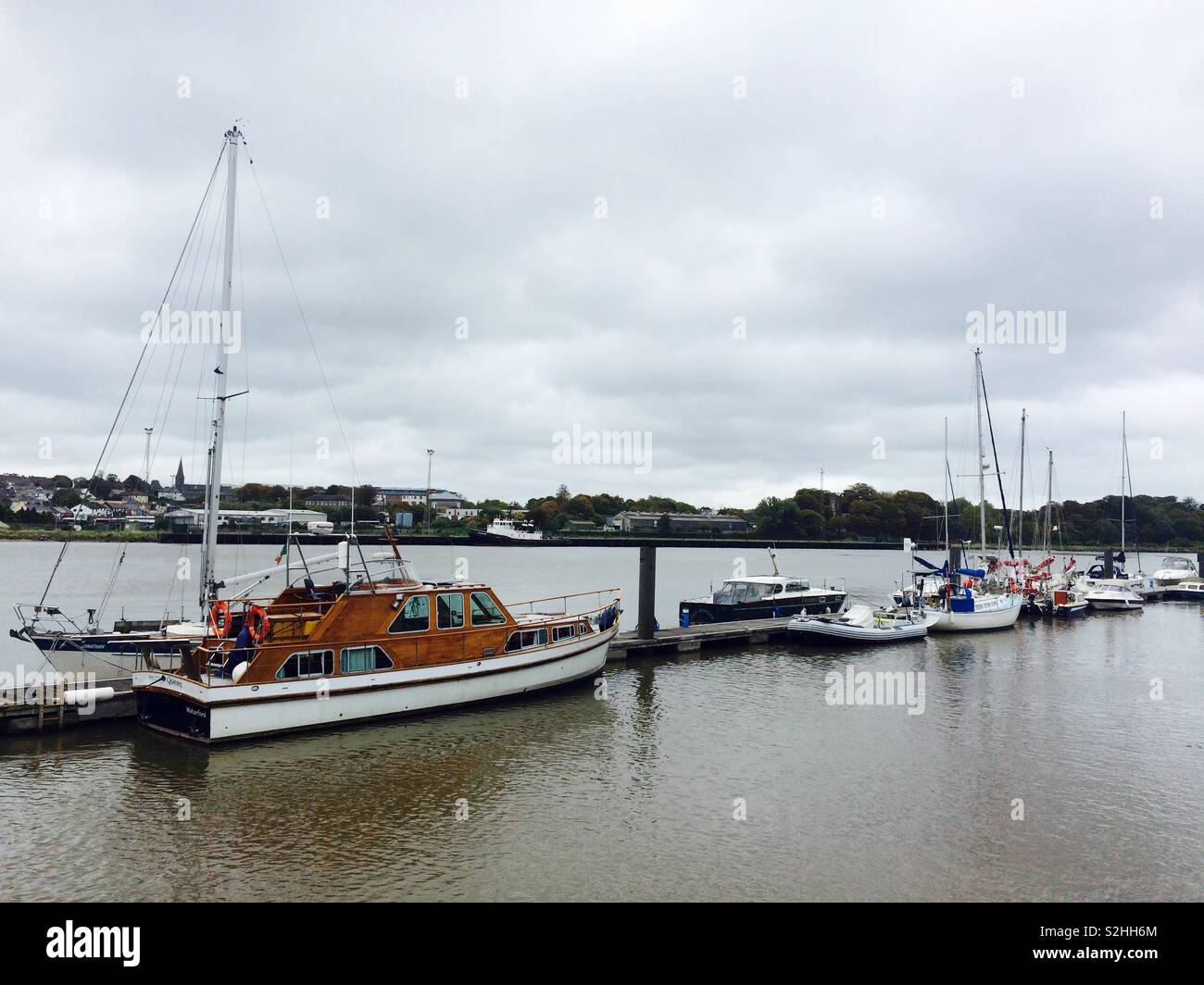 Yachts and boats moored at the jetty or walkway on a river in Waterford Ireland Stock Photo