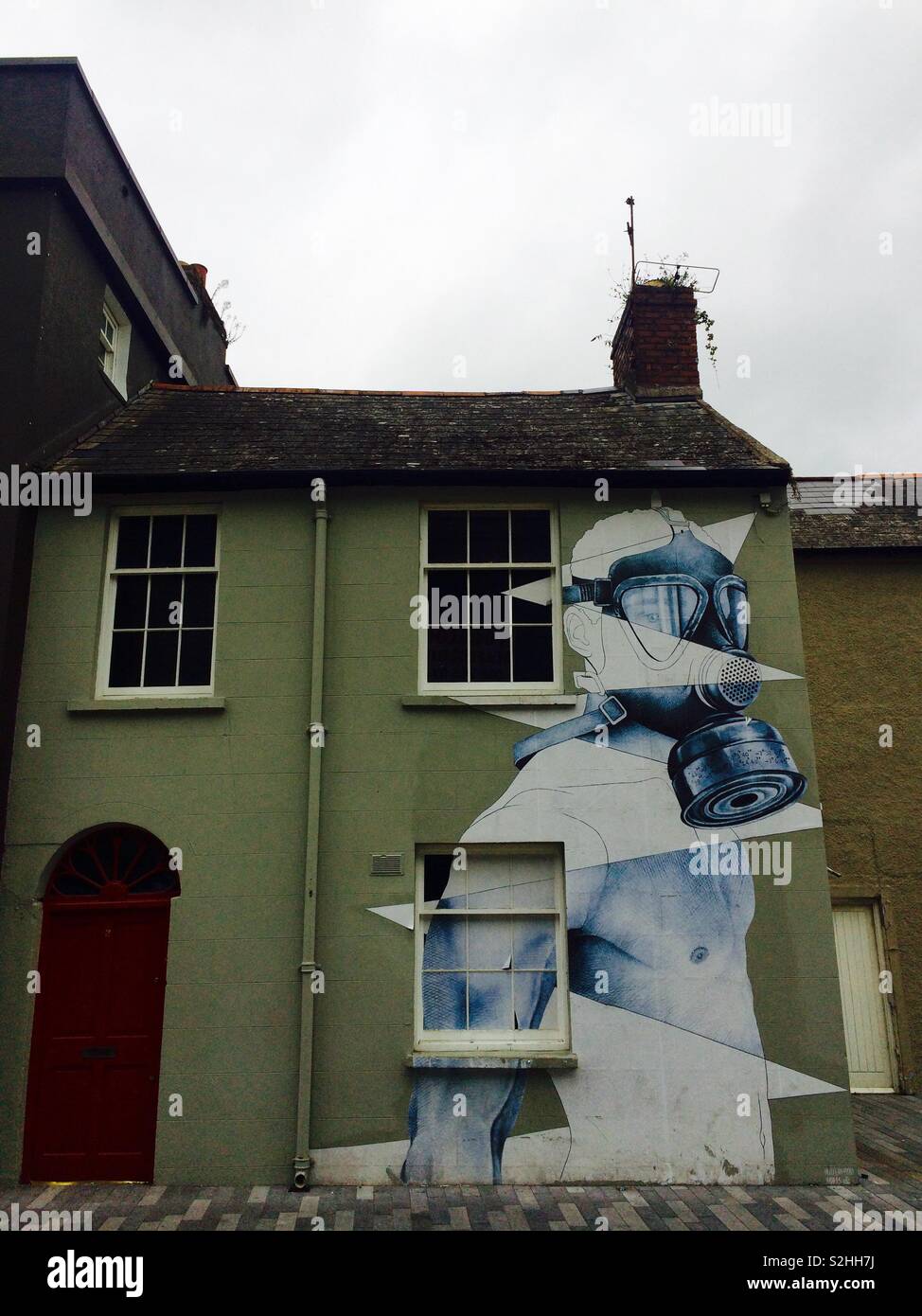 Building in Waterford, Ferrybank Ireland with amazing graffiti artwork of a man in a gas mask on the facade - Smartphone Captured Stock Image