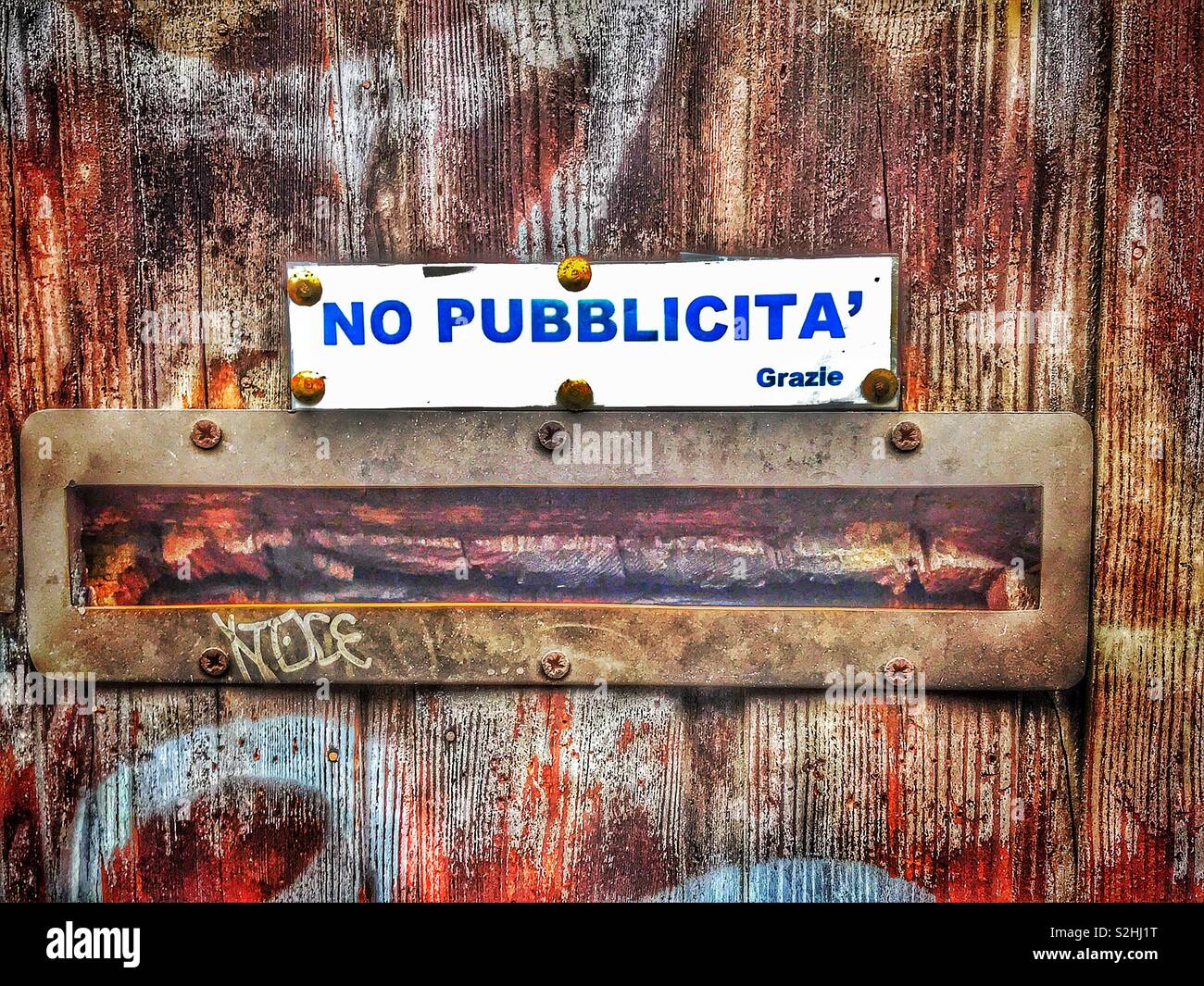 No Junk mail please, Italian style...no pubblicita grazie....request above letter box of weathered wooden door Stock Photo