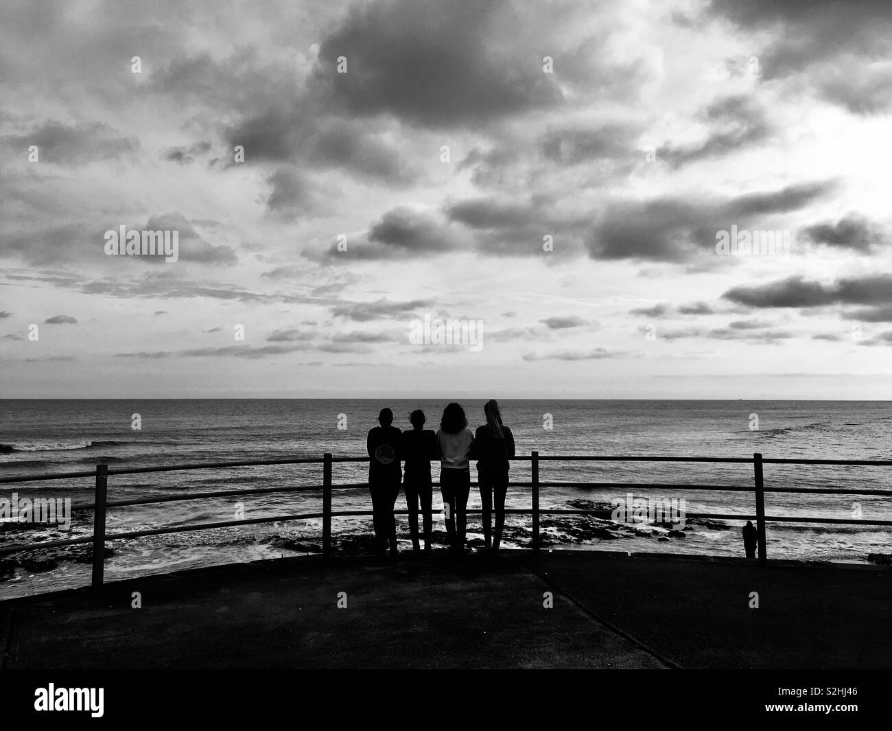 Figures looking out to sea Stock Photo